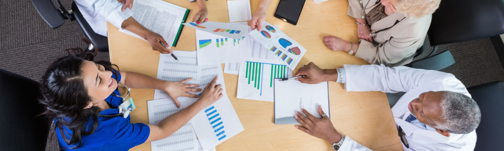 last image Image of people gathered around a desk discussing policy documents